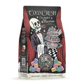 The front of a 12 ounce bag of Bones Coffee Company Coco Crush coffee. Its flavor is coconut macaron, and it has a skeleton dressed in a suit and bowtie holding a tray of macarons with a rose between its teeth.