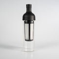 A black colored Hario filter-in coffee brew bottle that has a glass see-through bottom.