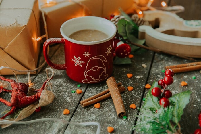 cup of coffee on table surrounded by spices and holiday ornaments