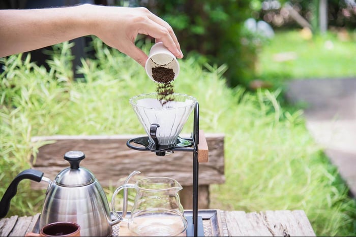 person making fresh drip coffee outdoors