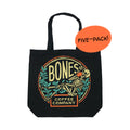 A black tote bag that has the classic Bones Coffee Company logo on it. The logo has a skeleton drinking coffee resting on greenery on it. A sticker says five-pack on it.