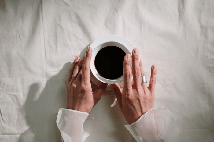 Female hands holding a coffee cup. 
